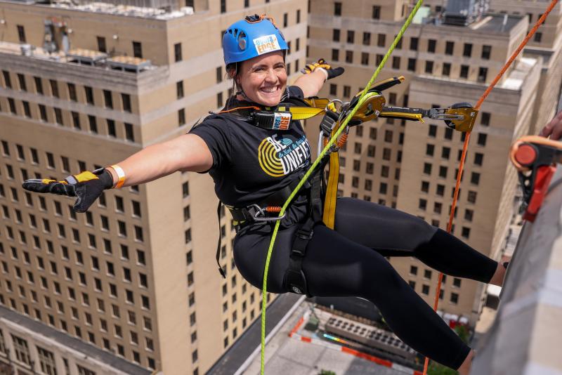 Lewes Elementary special education teacher Devon Reber goes hands-free as she prepares to rappel down the building.